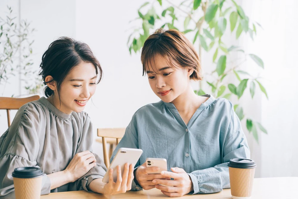 スマホを見るふたりの女性